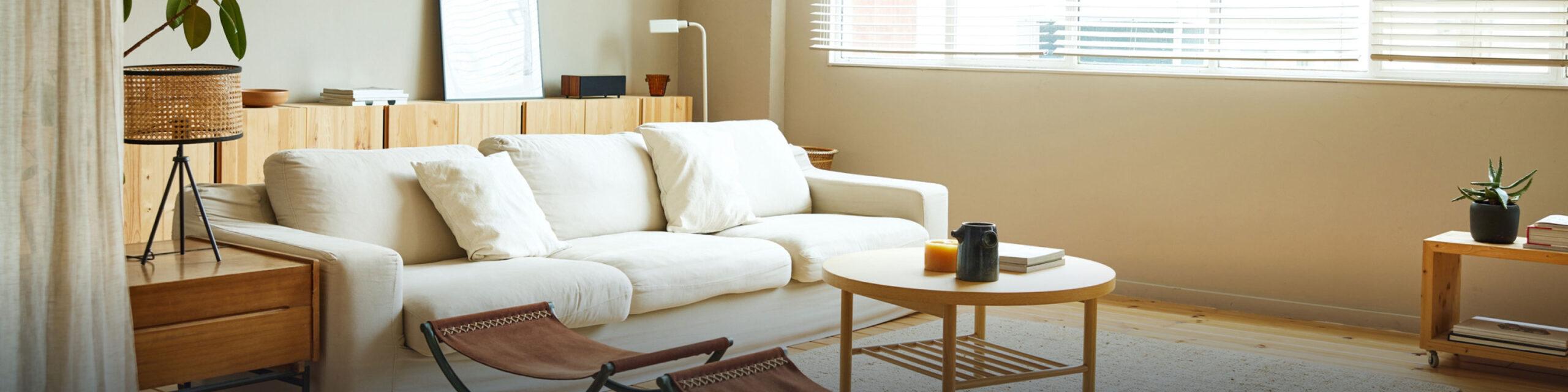 A view of living room with wood floors and a white couch.