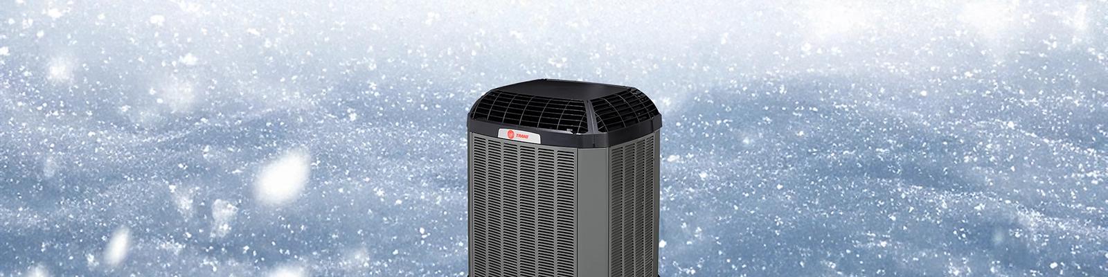 A Winter Scene with the words Trane’s New Cold Climate Heat Pumps superimposed.